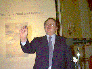 Patrick Winston speaks in front of a projected slide with the title "Reality, Virtual and Remote"