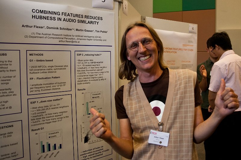 Arthur Flexer giving two thumbs up in front of a conference poster